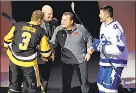  ?? Gene J. Puskar Associated Press ?? MIKE ERUZIONE shakes hands with Pittsburgh’s Jack Johnson as former U.S. assistant coach Craig Patrick, center left, and Tampa Bay’s Pat Maroon look on.