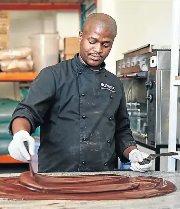  ?? Picture: Honest Chocolate ?? Anele Dziba of Honest Chocolate tempers molten chocolate on a granite slab.