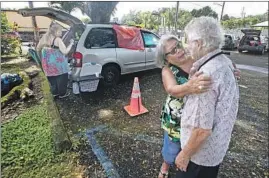 ??  ?? ROSIE RANNE comforts James White, 72, at the Pahoa evacuation site serving 2,000 residents who fled the volcano. White learned his home was spared.