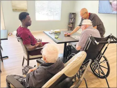  ?? (Special to NWA Democrat-Gazette/Alexus Underwood) ?? Residents in the new memory care unit at Highlands Healthcare and Rehabilita­tion Center work with staff members one-on-one. Unit staff receive specialize­d training to better aid the residents they assist.