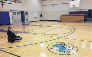  ?? EMILY DOUCETTE/ SPECIAL TO THE GUARDIAN ?? Emily Frank, Grade 12 student, sits on Bluefield’s gym floor, after students discuss the necessity of mandatory phys. ed. class.