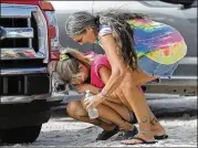  ?? GERALD HERBERT / AP ?? Nancy Register (left), comforted by Roxie Cline, weeps after finding no trace of the large camper where she lived or an old, black-and-white photo of her late mother Wednesday in Mexico Beach, Fla.