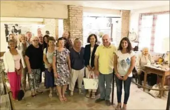  ??  ?? Les Amis du Musée et leur présidente Sandrine Hizebry en visite au musée de la poterie de Michel Ribero, posent devant l’effigie du peintre vallaurien Honoré Camos. (Photo Ph. D.)
