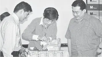  ??  ?? LAUNCHING CEREMONY: Dr Ngian (centre) performs the symbolic launch of the programme.