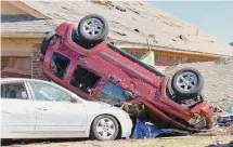  ?? ?? Vehicles sit against a home on Monday in Norman, Okla., after a tornado passed through the area.