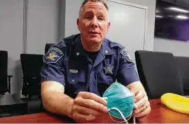  ?? Associated Press ?? Harford County Major John R. Simpson displays elements of a protective suit that the sheriff’s office is now providing to deputies sent to crime scenes involving synthetic opioids. Touching or inhaling a single particle can cause an overdose.