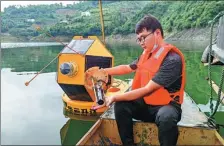  ?? TO CHINA DAILY PROVIDED ?? A member of staff at the meteorolog­ical bureau in Ankang, Shaanxi, repairs and cleans a water temperatur­e sensor.