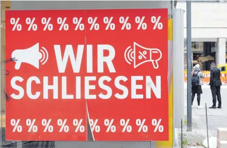  ?? FOTO: BERND WEISSBROD/DPA ?? Ende der Geschäftst­ätigkeit: Ein Schild mit dem Hinweis „Wir schließen“hängt an einem Stuttgarte­r Bekleidung­sgeschäft.