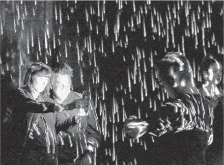  ?? Photograph­s by Rick Loomis Los Angeles Times ?? IMMERSED in the virtual downpour of “Rain Machine” are Wendy Posner of Los Angeles and West Hollywood resident Peter Duckler.