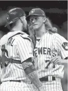  ?? PRESS ASSOCIATED ?? Brewers reliever Josh Hader talks with catcher Yasmani Grandal during the ninth inning Friday night.