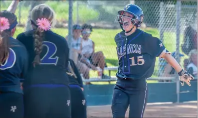  ?? Tom Cruze/For The Signal ?? Valencia batter Emma Bramson (15) gets a grand welcome at home plate after blasting a 3-run home run to give the Vikings a 4-3 lead over Hart in a softball game at Hart.