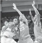  ?? GASTON DE CARDENAS/AP ?? Miami guard Davon Reed tries to get by Syracuse defenders Saturday in Coral Gables.