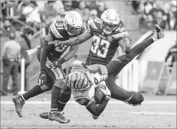  ?? Robert Gauthier Los Angeles Times ?? CHARGERS SAFETY Derwin James (33) knocks down Cincinnati Bengals receiver Cody Core in the fourth quarter with safety Adrian Phillips joining in. The Chargers won 26-21 to avoid a costly upset.