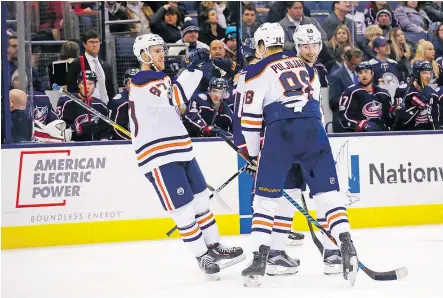  ?? — GETTY IMAGES ?? Connor McDavid congratula­tes fellow forward Jesse Puljujarvi on his third-period goal as the Edmonton Oilers trounced the Blue Jackets 7-2 Tuesday at Nationwide Arena in Columbus, Ohio.