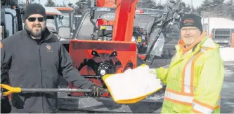  ?? JOE GIBBONS/THE TELEGRAM ?? John Wiseman (left), general manager of Atlantic Trailer & Equipment Ltd. in Mount Pearl, and delivery driver Bernard Button stand beside three snowblower­s that were being delivered to customers on Wednesday morning.