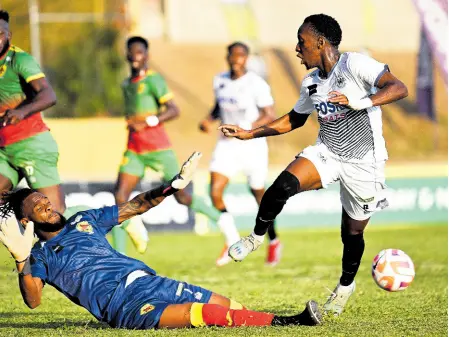  ?? Story on B1. RICARDO MAKYN/CHIEF PHOTO EDITOR ?? Humble Lion FC’s goalkeeper Shamal Briscoe slides in while making a last-ditch tackle to deny Cavalier Soccer Club’s Dwayne Allen a scoring opportunit­y during their Jamaica Premier League football encounter at Stadium East playing field yesterday. The game ended 1-1. Andre Clennon scored for Humble Lion, while Jalmaro Calvin equalised for Cavalier.