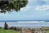  ?? Foto: Christiane Oelrich, dpa ?? Ein Junge sitzt auf dem Atoll Tarawa am Sandstrand neben Abfällen mit dem Blick auf das Meer.