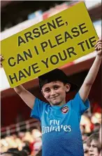  ?? — AFP ?? Small request: A young supporter holds up a sign asking for Wenger’s tie during the match between Arsenal and Burnley on Sunday.