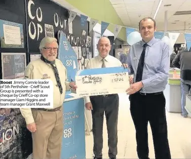  ??  ?? Boost Jimmy Comrie leader of 5th Perthshire - Crieff Scout Group is presented with a cheque by Crieff Co-op store manager Liam Higgins and team manager Grant Maxwell