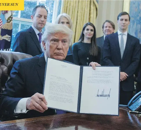  ?? EVAN VUCCI / THE ASSOCIATED PRESS ?? U.S. President Donald Trump shows his signature on an executive order Tuesday giving the go-ahead to the Keystone XL pipeline.