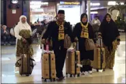  ?? TATAN SYUFLANA - THE ASSOCIATED PRESS ?? Indonesian­s who are scheduled to travel to Saudi Arabia for a minor pilgrimage, called ‘Umrah’, walk with their luggages as they are turned away from their flights at SoekarnoHa­tta Internatio­nal Airport in Tangerang, Indonesia, Thursday, Feb. 27.