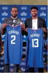  ?? AP Photo/Ringo H.W. Chiu ?? ■ Kawhi Leonard, left, and Paul George pose with their new team jerseys during a press conference Wednesday in Los Angeles.
