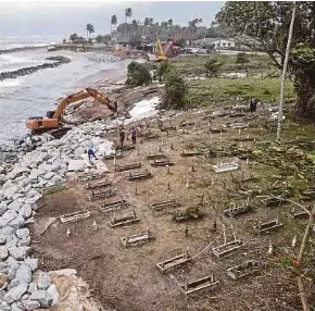  ?? ?? Kerja penambakan batu bagi menghalang hakisan pantai di Tanah Perkuburan Islam Pengkalan Maras, Kuala Nerus.