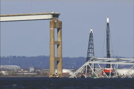  ?? JULIA NIKHINSON VIA ASSOCIATED PRESS ?? CRANES STAND BY AS THE WRECKAGE of the Francis Scott Key Bridge rests on the container ship Dali on Saturday in Baltimore.