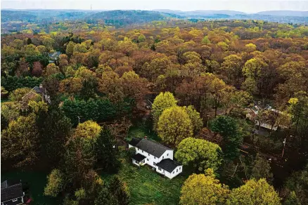  ?? MARK MIRKO/HARTFORD COURANT ?? An aerial view looking to the northeast of a white, two-story house on the corner of Orchard Road and Newton Road in Woodbridge shows the site of the Yale Law affordable housing proposal to develop the home into a four-unit affordable housing developmen­t.