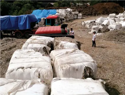  ?? SUNSTAR FOTO/ALLAN CUIZON ?? TRASH
PACKS. Packs of garbage allegedly shipped from Korea are dumped in a vacant lot in Barangay Tingub, Mandaue City.