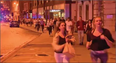  ?? The Associated Press ?? CHAOTIC SCENE: Image made from a video, people run from the scene an attack Saturday in London. Chaos broke out for several minutes during Saturday night's attack in the heart of the city, with people scattering in all directions, sometimes directly...