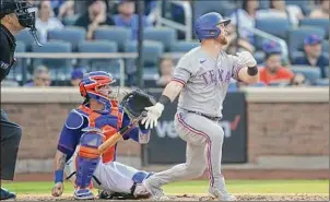  ?? John Minchillo / Associated Press ?? The Rangers’ Kole Calhoun hits a solo home run off Mets’ fill-in starter Trevor Williams in the fourth inning on Saturday in New York. Calhoun also tagged Williams for a three-run homer in the second, going back-to-back with Jonah Heim, who followed with a solo shot. Williams, who got the spot start after Chris Bassitt went on the injured list, allowed five runs, five hits and one walk over 3 2/3 innings.