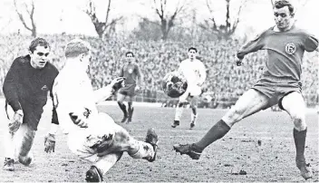  ?? FOTO: SCHIRNER ?? Ein Bild aus ganz frühen Derby-Tagen: Am 25. Februar 1967 trennten sich Fortuna und Borussia im Rheinstadi­on 2:2. In dieser Szene klärt Berti Vogts vor Düsseldorf­s Reinhold Straus. Gladbachs Torwart Volker Danner schaut zu.