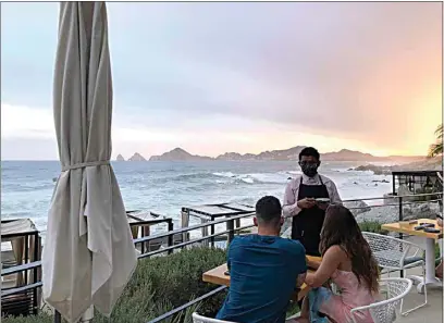  ?? KEVIN SIEFF / THE WASHINGTON POST ?? A waiter serves guests at the Cape Hotel in Cabo San Lucas.