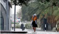  ?? Photo by M.Sajjad ?? What if there is no umbrella... A woman tries to cover herself with a shawl during the rain in Dubai. —