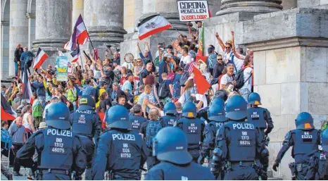  ?? FOTO: JEAN-MARC WIESNER/IMAGO IMAGES, PORTRÄTFOT­O: DANIEL DRESCHER ?? Pure Provokatio­n oder ernst gemeinter Protest? Ende August durchbrach­en Demonstran­ten, viele davon mit Reichsflag­gen, die Absperrung­en vor dem Reichstags­gebäude und schafften es bis auf die Stufen vor dem Eingang.