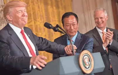  ?? GETTY IMAGES ?? President Donald Trump shakes hands with Foxconn Chairman Terry Gou as Sen. Ron Johnson claps during an announceme­nt that the company will open a manufactur­ing facility in Wisconsin.