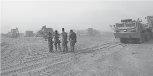  ?? KHALID MOHAMMED/THE ASSOCIATED PRESS ?? U.S. Marines prepare to build a military site during a sandstorm Monday in western Anbar, Iraq. The U.S.-led coalition’s newest outpost in the fight against the Islamic State is in this dusty corner of western Iraq near the border with Syria, where...