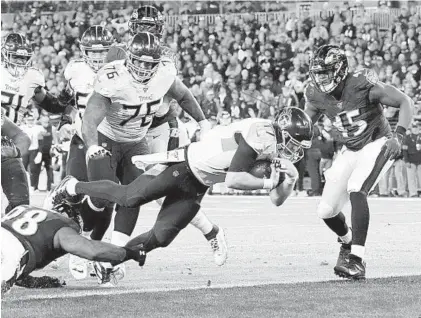  ?? KARL MERTON FERRON/BALTIMORE SUN ?? Tennessee Titans’ quarterbac­k Ryan Tannehill dives into the end zone for a touchdown in the third quarter against the Ravens.