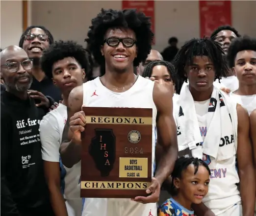  ?? KIRSTEN STICKNEY/SUN-TIMES ?? Calvin Robins Jr. holds the trophy after Kenwood defeated Oak Lawn on Friday to win its regional championsh­ip. He had 11 points and eight rebounds.