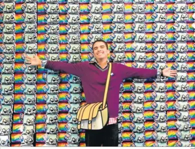  ?? EFE ?? El creador del gato Nyan, Chris Torres, posa con una reproducci­ón de su obra, vendida por más de medio millón de euros.
