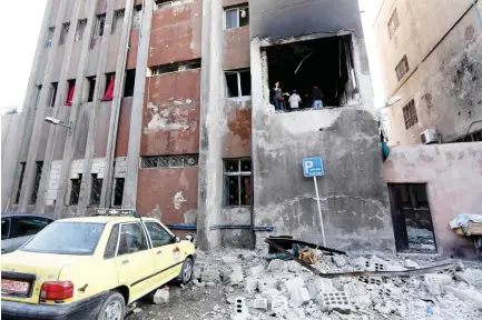  ??  ?? Syrians check the site of a double suicide bomb attack which hit the Al-Midan police station in Damascus on Monday. (AFP)