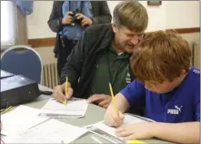  ?? PROVIDED PHOTO ?? Cub Scout Angelo Hill, right, fills out his log sheet after making a contact by Amateur Radio during Saturday’s Jamboree on the Air. Helping his is Amateur Radio operator Russ Greenman,WB2LXC, of the East Greenbush Amateur Radio Associatio­n.