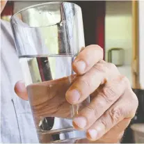  ??  ?? Steve Wolfson drinks water from the tap at his home, which is outfitted with a Brita drinking water filter.