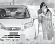  ?? BEACH POST
LANNIS WATERS/PALM ?? A health care worker prepares to test a person for COVID-19 at the FITTEAM Ball Park of the Palm Beaches drive-through facility in West Palm Beach on Jan. 7.