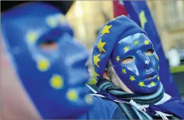  ?? DANIEL LEAL-OLIVAS/AFP ?? Pro-European Union, anti-Brexit demonstrat­ors wear masks featuring the EU flag outside the Houses of Parliament in central London on December 18.