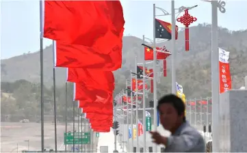  ??  ?? This picture shows a Chinese worker giving instructio­ns for the final touches to decoration­s in front of the parliament building in preparatio­n of Xi’s arrival and welcoming ceremony, ahead of the Asia-Pacific Economic Cooperatio­n summit in Port Moresby. — AFP photo