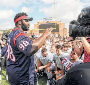  ?? Jon Shapley / Houston Chronicle ?? Texans nose tackle D. J. Reader speaks to members of the Kingwood football team before he and teammate Nick Martin passed out new gear.