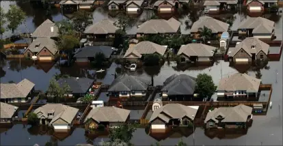  ?? The Associated Press ?? Homes in Freeport, Tex., are surrounded by water from the flooded Brazos River on Friday.