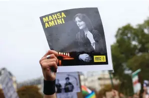  ?? The Associated Press ?? ■ A protester shows a portrait of Mahsa Amini during a demonstrat­ion Sunday in Paris to support Iranian protesters demonstrat­ing against the death of a young woman in police custody. Anti-government demonstrat­ions erupted Saturday in several locations across Iran as the most sustained protests in years against a deeply entrenched theocracy entered their fourth week. The protests erupted Sept. 17 after the burial of 22-year-old Amini, a Kurdish woman who died in the custody of Iran’s feared morality police.
